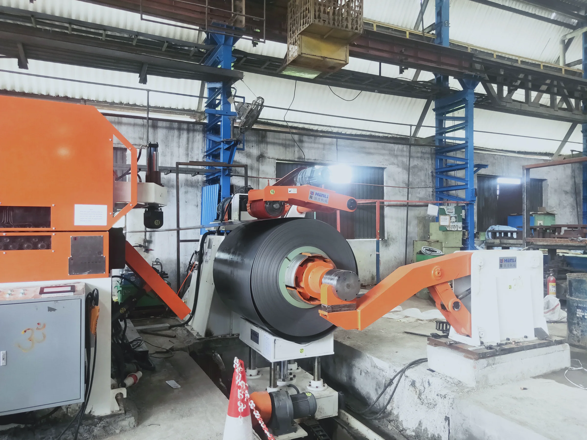 Bobina metálica montada en un desbobinador HENLI para revisar ancho, diámetro interior y diámetro exterior
