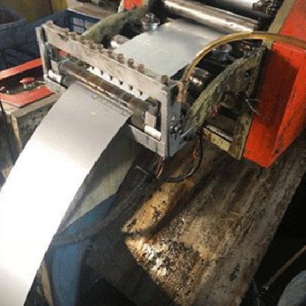Tira metálica atravesando los rodillos de un alimentador de aceite instalado
