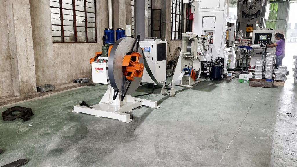 Alimentador de pinza HG instalado junto a una prensa de estampado de alta velocidad