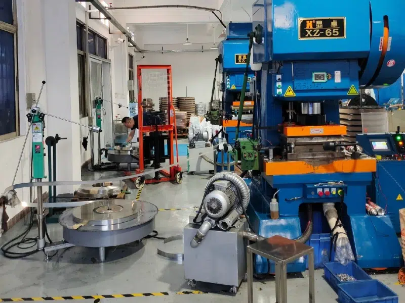 Prensa azul con unidad gris y recortes sueltos visibles cerca del alimentador